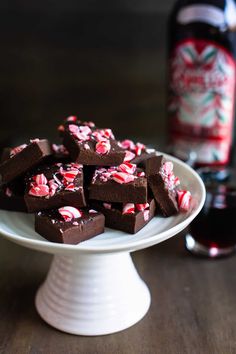 a white plate topped with chocolate fudges next to a bottle of booze