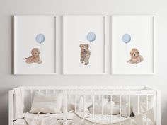 three framed pictures hang above a crib in a baby's room with white bedding