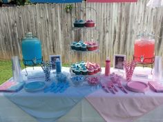 a table topped with cupcakes and desserts next to a fenced in area