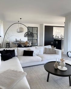 a living room filled with white furniture and black accents