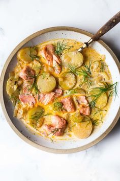 a white bowl filled with potatoes and salmon