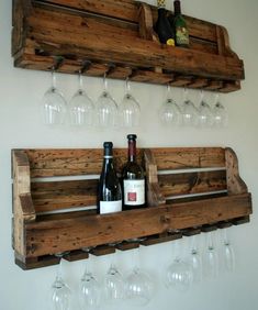 wine glasses and bottles are sitting on a wooden shelf with wine glasses hanging from it