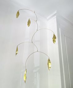 a wind chime hanging from the ceiling in a room with white walls and windows