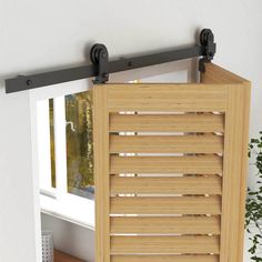 an open window with wooden shutters in front of it and a potted plant next to it