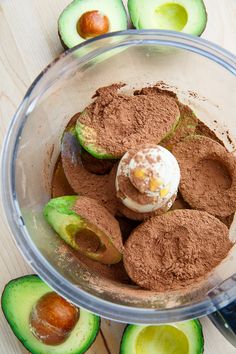 an avocado and chocolate in a food processor with some cut up cucumbers