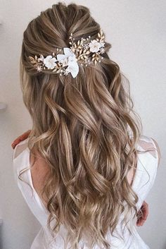 the back of a woman's head with wavy hair and flowers in her hair