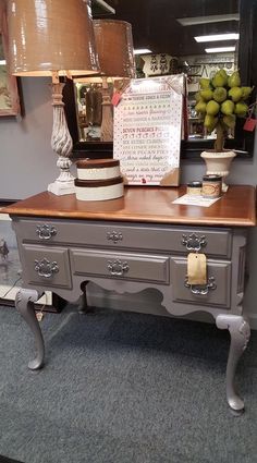 a table with two lamps on top of it next to a mirror and lamp shade