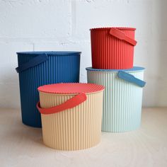 three different colored buckets sitting next to each other