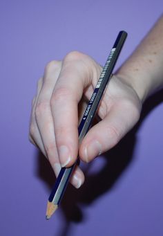 a person holding a pencil in their left hand