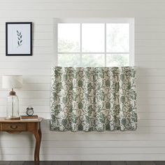 a blue and white curtain hanging on the side of a wall next to a table