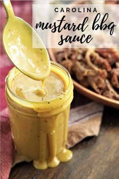 a spoon full of mustard sauce being poured into a jar with meat in the background