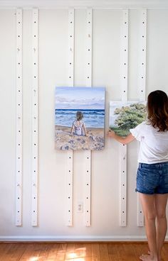 a woman standing in front of a painting on the wall