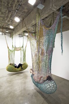 two suspended hammocks in an empty room