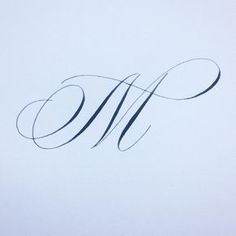 the word w is written in cursive writing on a sheet of white paper