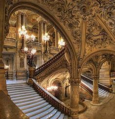 an ornate staircase with chandeliers in a building