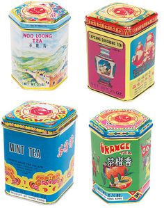 four tins of various types of tea in different colors and designs on white background