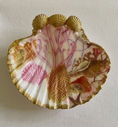 a decorative shell shaped dish on a white surface