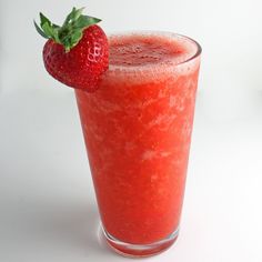 a tall glass with a strawberry on the rim next to a strawberries garnish