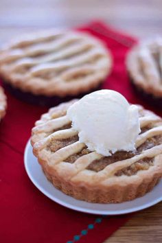 two small pies with ice cream on top are sitting on a red tablecloth