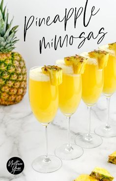 pineapple mimosas in glasses on a marble counter