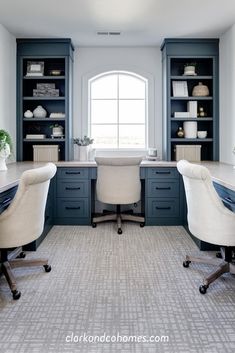 two white chairs sitting in front of a desk