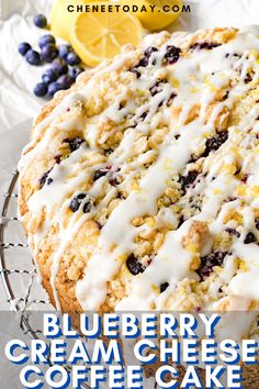 blueberry cream cheese coffee cake on a cooling rack with lemons and blueberries