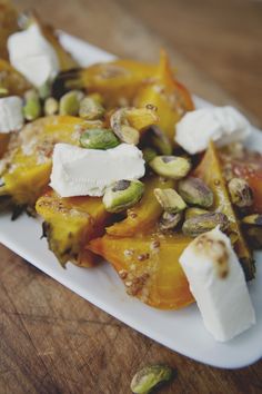 a white plate topped with lots of food on top of a wooden table