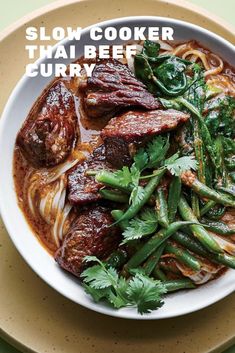 a bowl filled with meat and noodles on top of a table