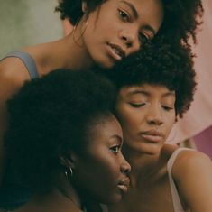 three women are looking at something on the screen