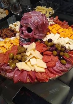 a platter filled with meats, cheeses and olives