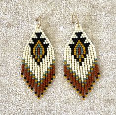 two pairs of beaded earrings sitting on top of a carpet