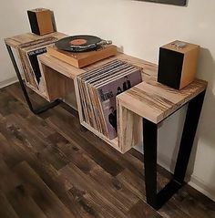 an old record player sits on top of a wooden table with vinyl records in front of it