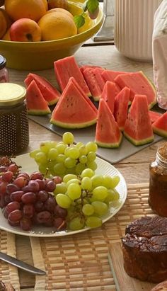 a table topped with lots of different types of fruit on plates and bowls next to each other