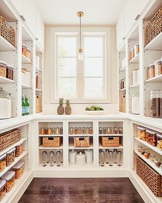 an organized pantry with lots of shelves and baskets