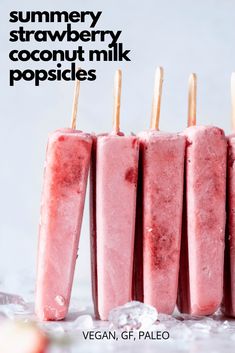 four popsicles are lined up on ice with strawberries in the background and text that reads, summer strawberry coconut milk popsicles