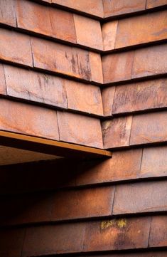 the corner of a building made out of metal sheets with rusted paint on it