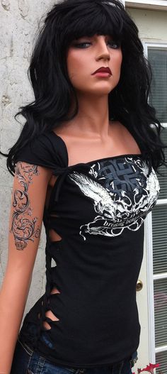 a female mannequin with black hair and tattoos on it's arms, wearing a black top