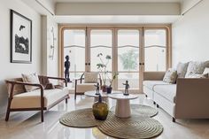 a living room with two couches and a coffee table in front of large windows