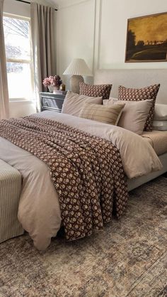 a bedroom with a large bed covered in blankets and pillows