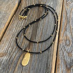 "Dainty Double Strand Beaded Necklace with Black Faceted Czech Glass Beads and an accent 10K Gold (plated) Oval Pendant. Beads: * Black Czech Glass - 1mm * Gold Spacer Beads - 2mm Pendant: * 10K Gold (plated) Oval Pendant - 9x22mm Clasp: *Gold Plated Lobster Claw Clasp * The model in the pictures is wearing 16 & 18 inches. Choose your Lengths at Checkout! 2.5\" Extender Chains also available To view more of my original jewelry designs, visit: https://www.etsy.com/shop/TheBeadCounter" Black Beads Necklace Designs, Gold Necklace Minimalist, Genuine Turquoise Jewelry, Black And Gold Necklace, Navy Jewelry, Black Beaded Necklace, Necklace Minimalist Jewelry, Oval Pendant Necklace, Original Jewelry Design