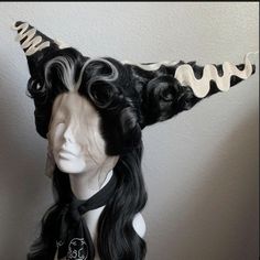 a mannequin head with long black hair and horns on it's head