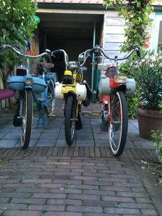 two bikes parked next to each other on a brick walkway in front of a house