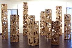 several cardboard boxes stacked on top of each other in front of a wall with windows