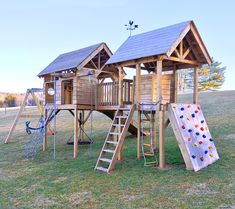 a wooden play set with a slide and climbing frame in the grass next to it