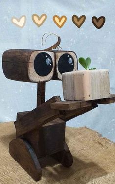 a wooden robot holding a cake on top of a table