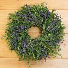 a wreath made out of lavender flowers on a wooden surface