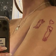 a woman with a tattoo on her chest holding a cell phone