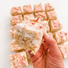 someone holding up a piece of cake with white frosting and sprinkles