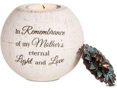 a white candle holder with a blue flower on it and the words in remembrance of my mother's eternal light and love