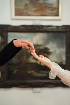 the bride and groom are exchanging their wedding rings in front of an old - fashioned painting